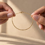Morse Code Bracelet held between fingers