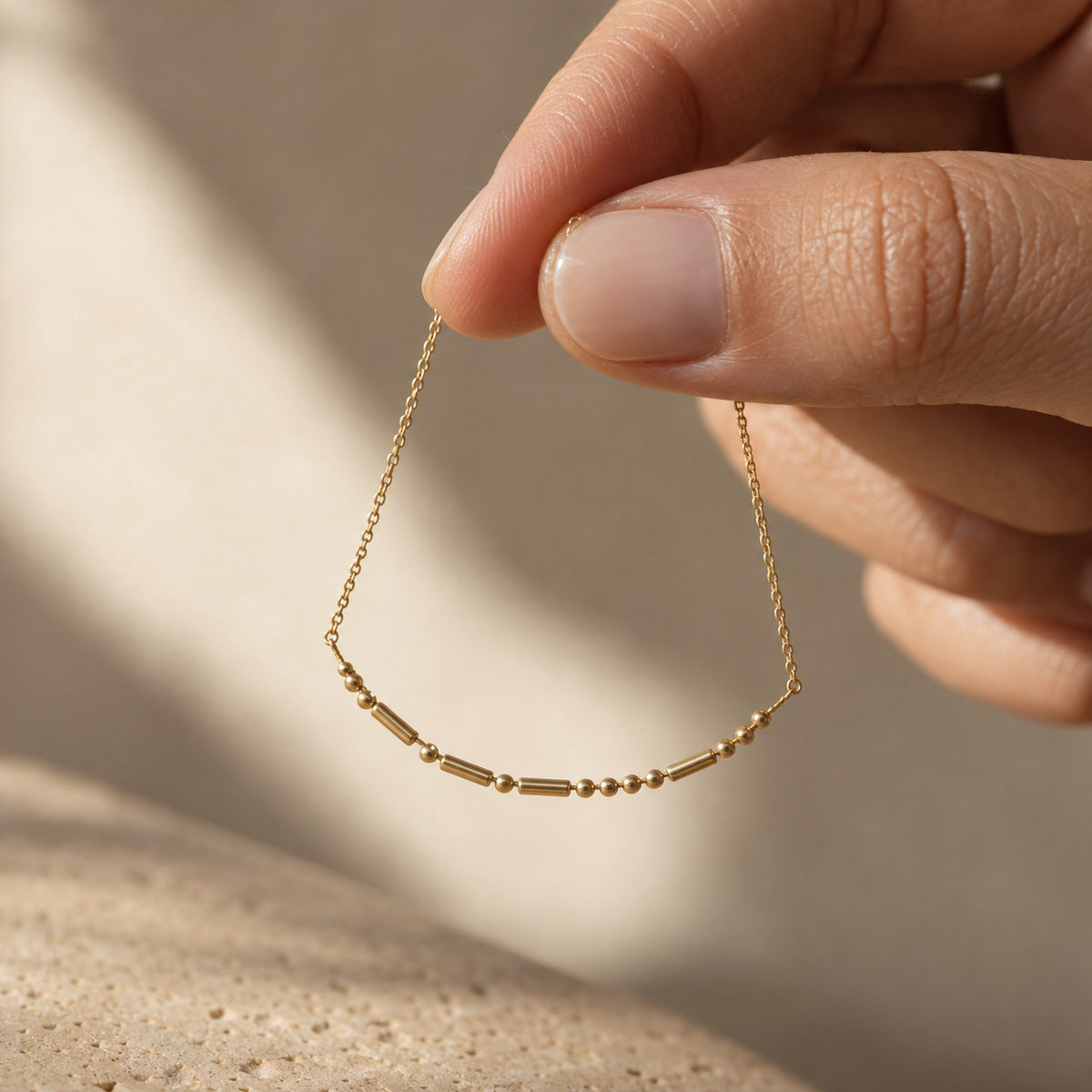 Morse Code Necklace held between fingers