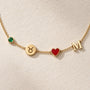 Close-up of birthstone, zodiac, heart and initial charms on necklace
